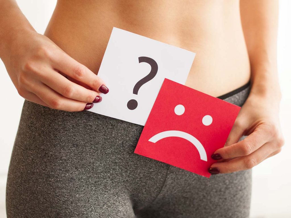 woman with question mark and sad face sign over crotch area