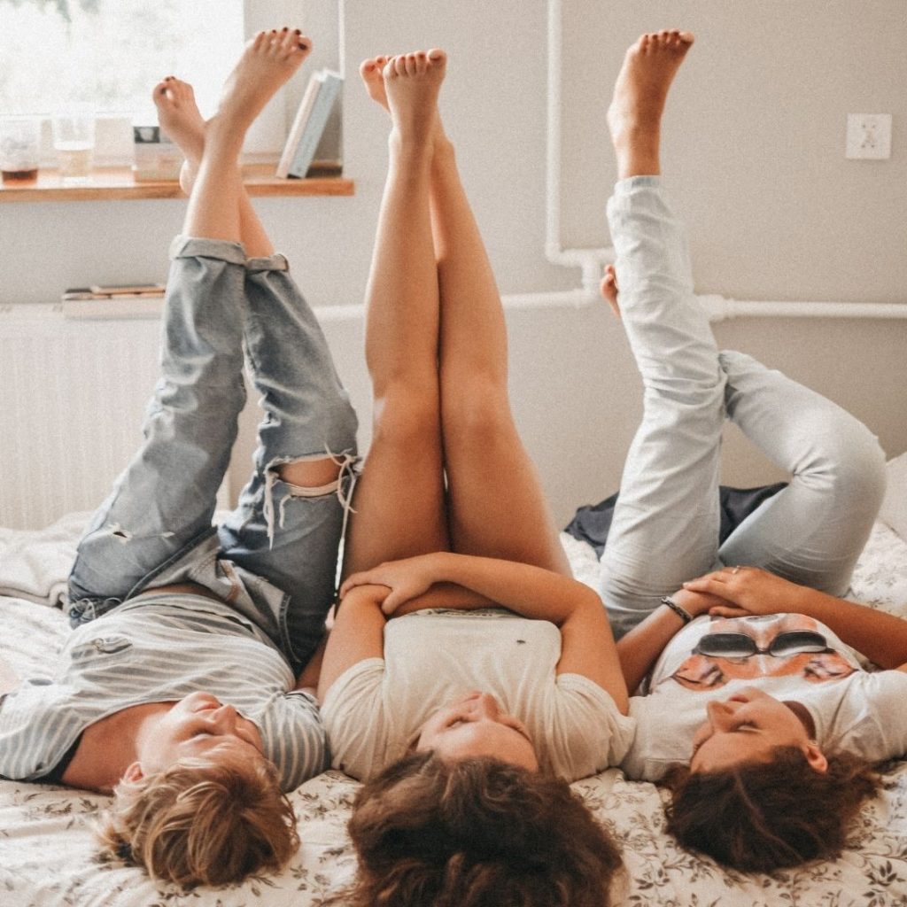 three woman hanging out in dorm room